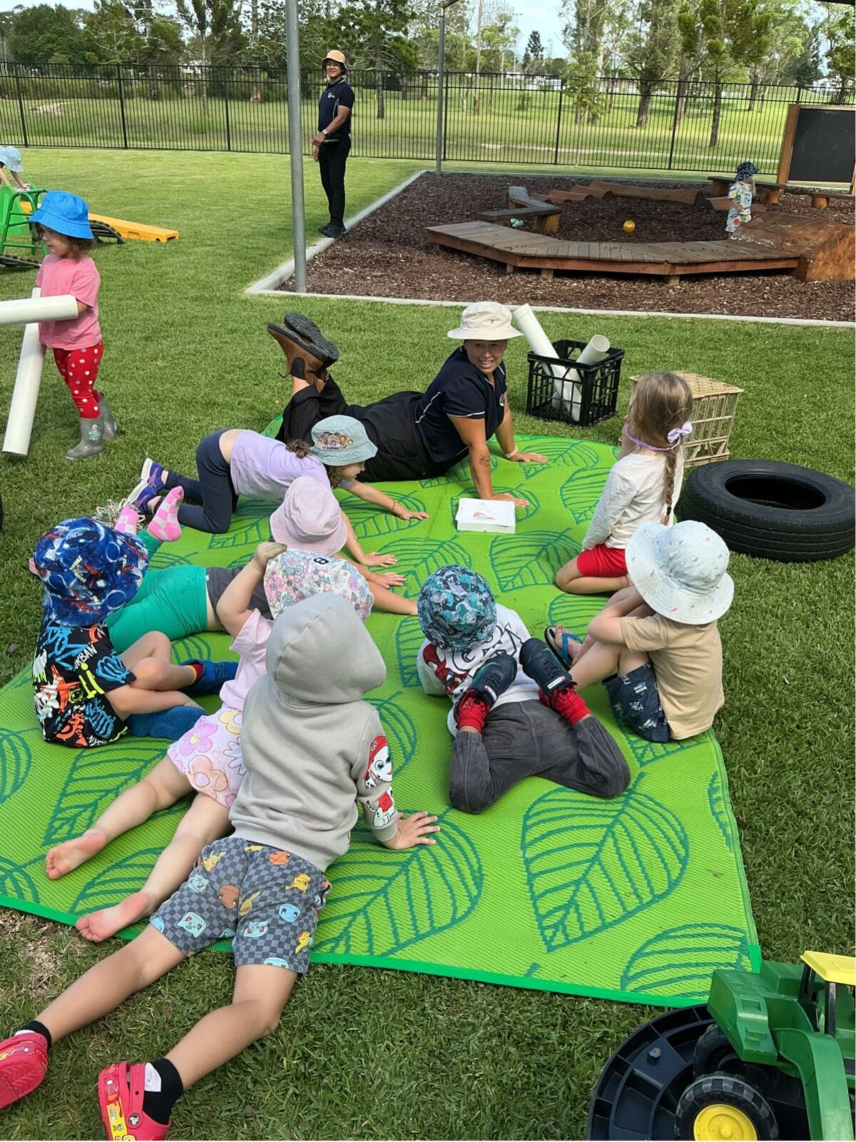 Children exploring the sandpit with an educator at Explorers